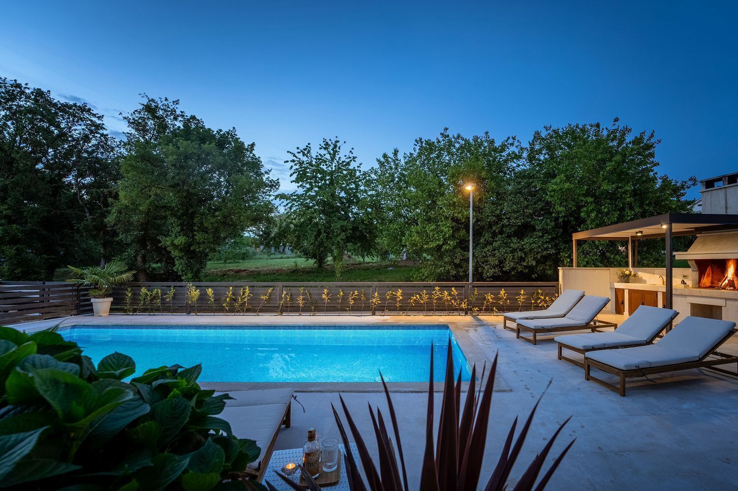 A swimming pool with lounge chairs and a barbecue area.
