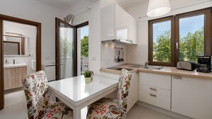 Une cuisine moderne avec une table à manger, des chaises et une machine à café.