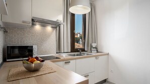 A modern kitchen with a microwave, sink, and a bowl of fruit on the counter. - Mediterranean flat with saltwater pool, jacuzzi and only 100 metres to the beach (Funtana)