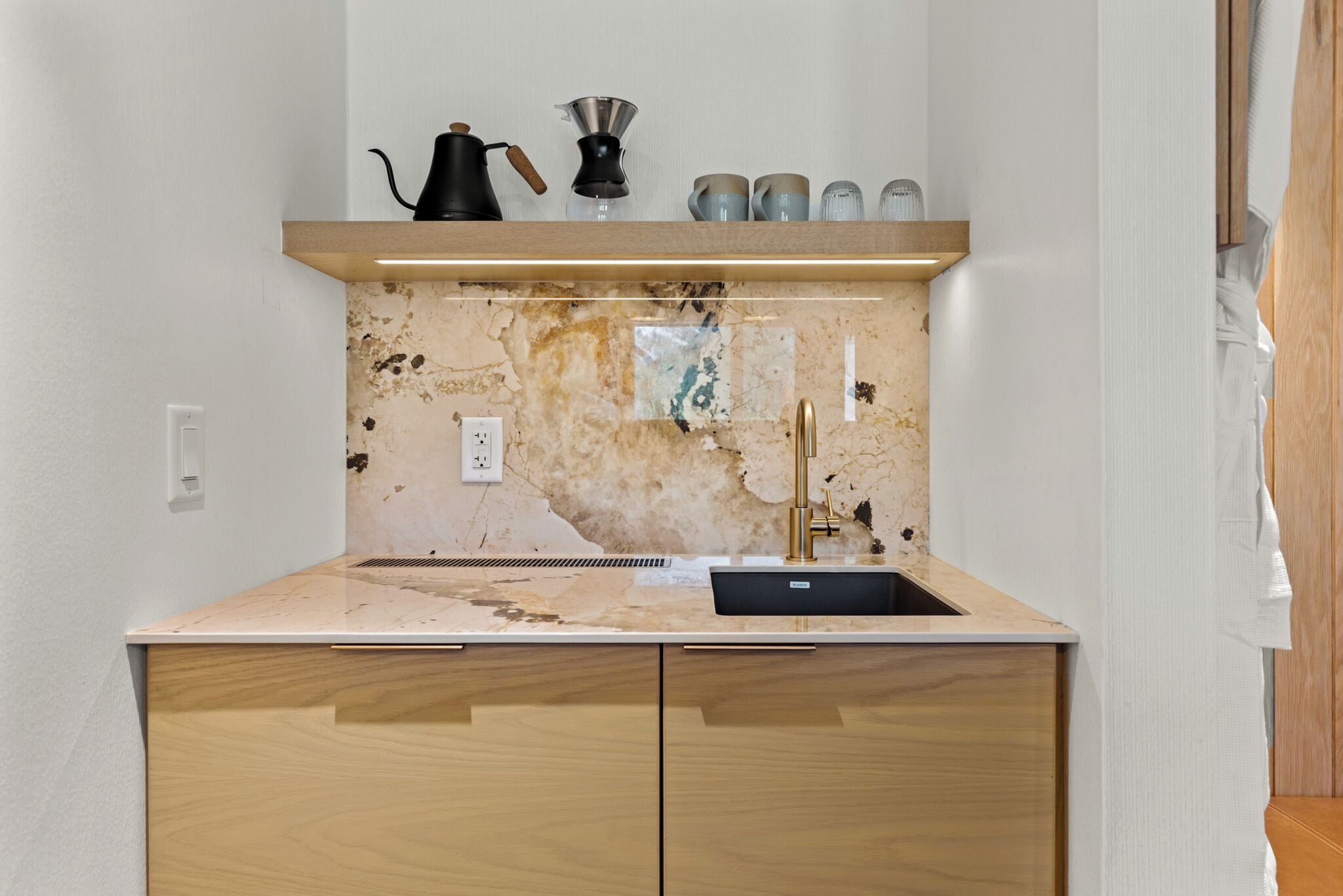 Eine Küche mit Spüle, Arbeitsplatte und einer Spritzschutzwand mit abgenutztem Design.