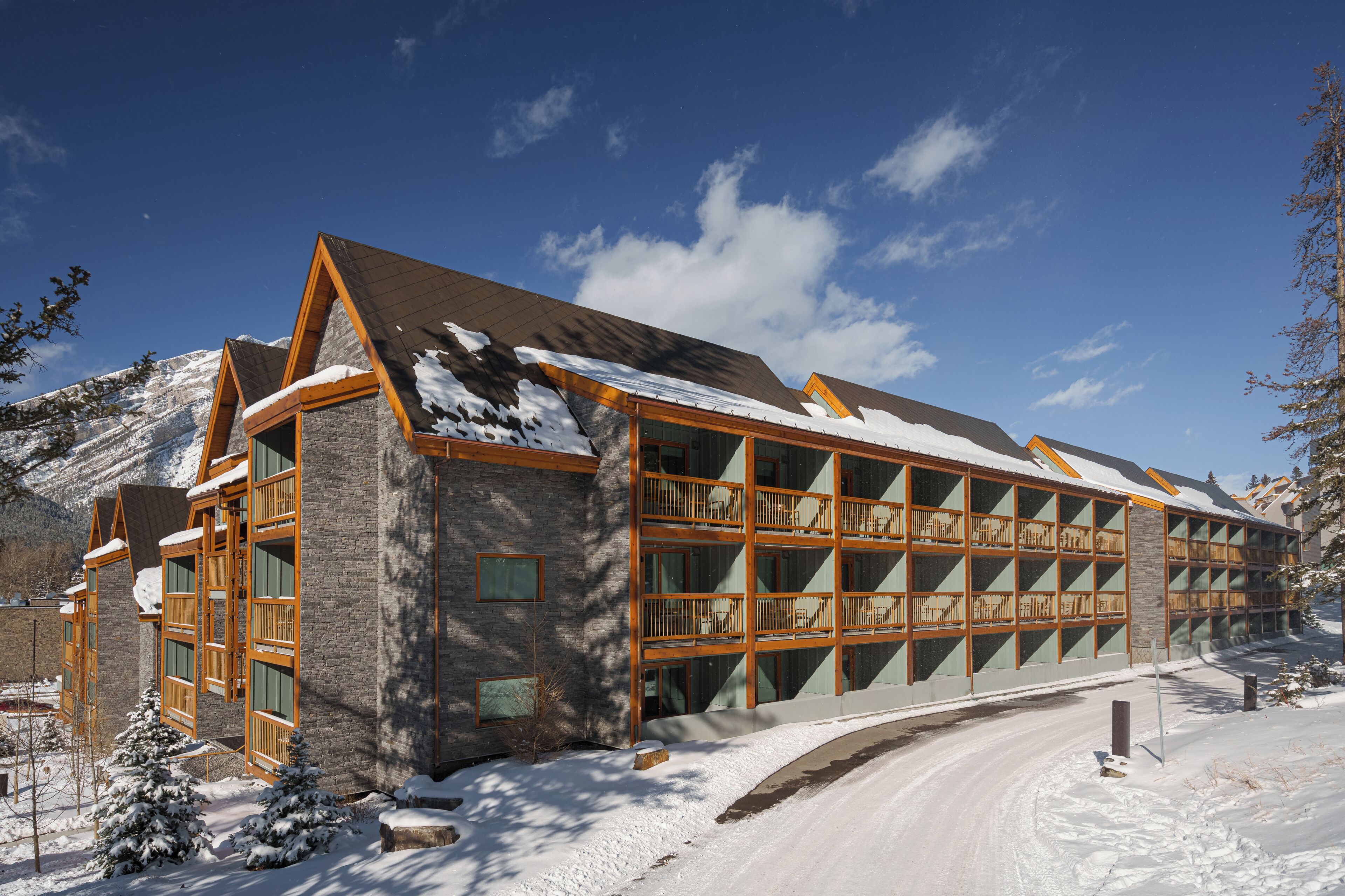 Un bâtiment à la façade en pierre, doté de nombreux balcons et dont le toit est recouvert de neige.