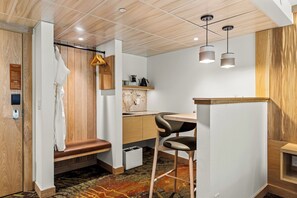 A modern kitchen with wooden accents, a bench, and a bar area.