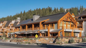 A lodge with multiple guest rooms, outdoor seating, and a stone retaining wall.