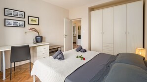 A bedroom with a bed, a desk, and a wardrobe. - Idyllic flat just a few minutes' walk from the beach with private balcony, air conditioning, barbecue, WiFi (Porec)