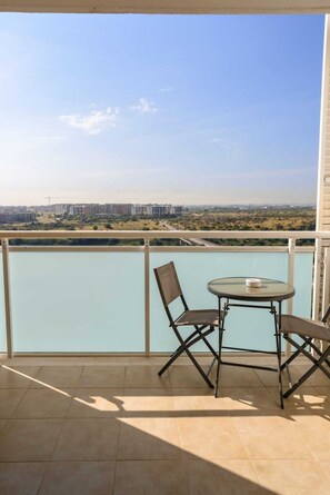A balcony with a table and chairs, overlooking a cityscape and a body of water. - LUXURY 2 (Bari)