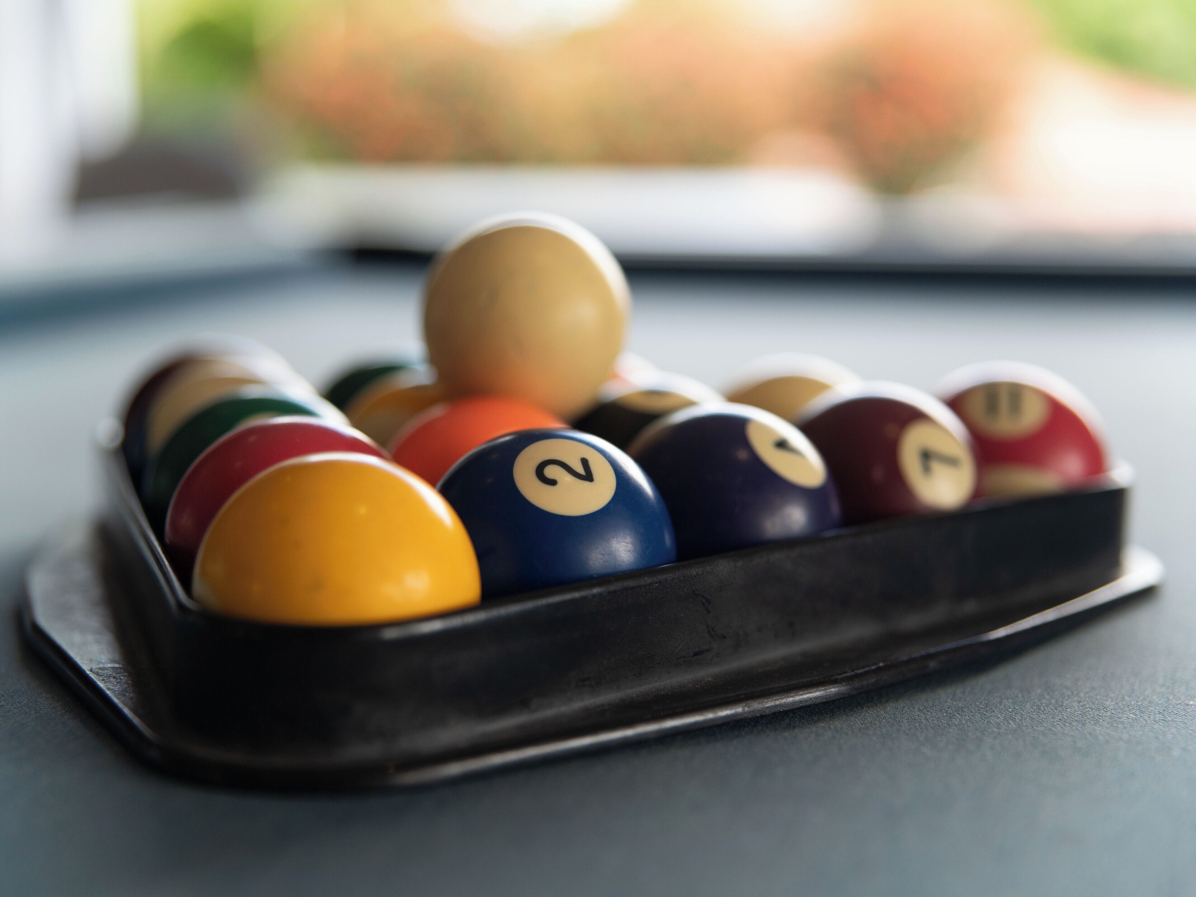 A pool table with billiard balls in a rack.