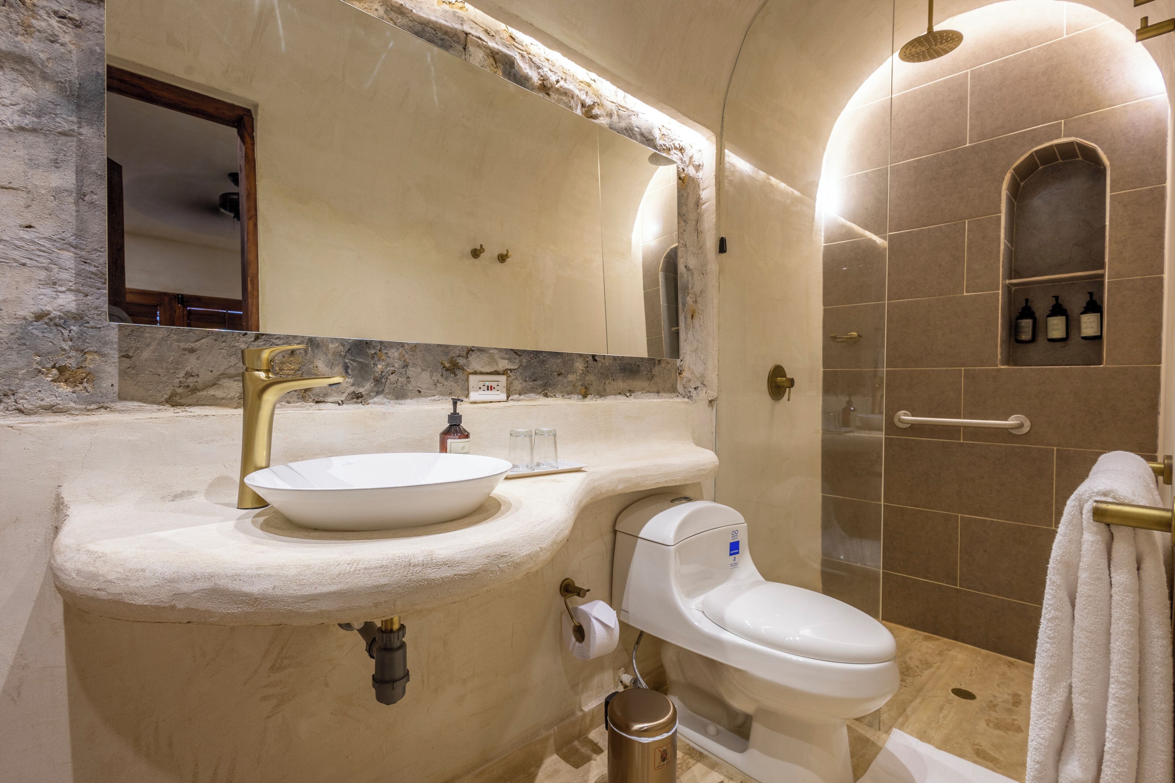 Een badkamer met een marmeren wastafel, toilet en douche.