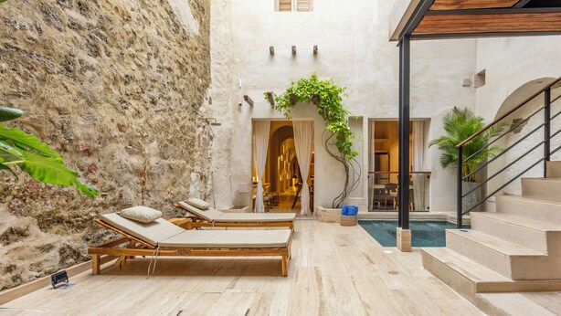 A spa area with two wooden loungers, a pool, and a staircase. - Casa Fernández Cartagena (Cartagena)