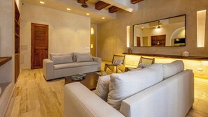 A modern living room with a sofa, armchairs, and a coffee table. There is a wooden ceiling and a large mirror on the wall. - Casa Fernández Cartagena (Cartagena)
