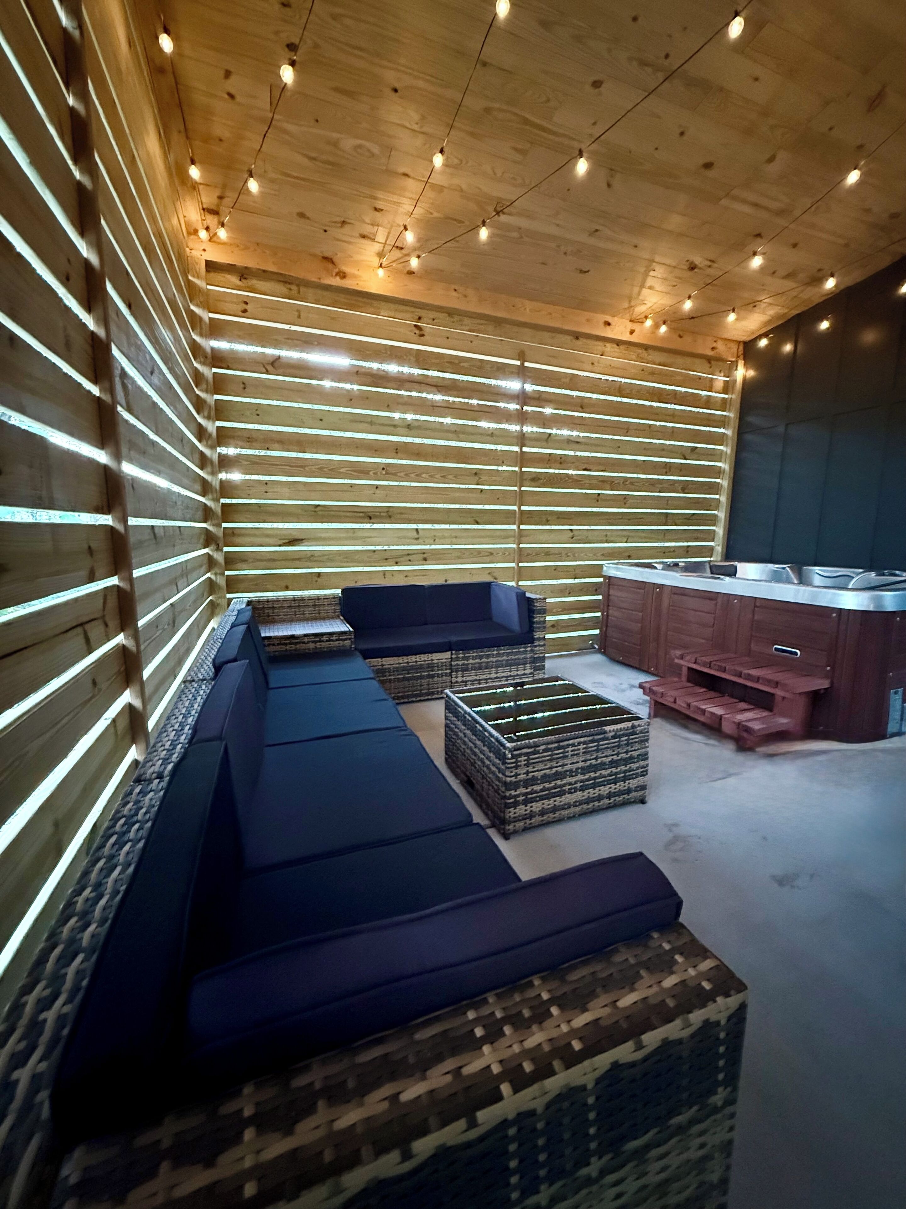 Un intérieur moderne avec un long banc, des poufs en osier et un banc intégré avec une finition en bois.