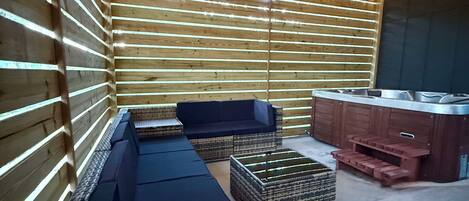Un intérieur moderne avec un long banc, des poufs en osier et un banc intégré avec une finition en bois.