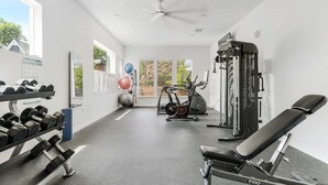 A gym with dumbbells, exercise balls, a bench, and a weight machine. - Downtown Modern Bungalow (Dallas)