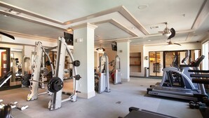 Ett gym med styrketräningsmaskiner, löpband och en takfläkt.