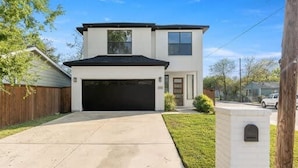 A two-story house with a garage, a front yard, and a mailbox. - Trinity Groves Retreat Large Modern 5 BR Home (Dallas)