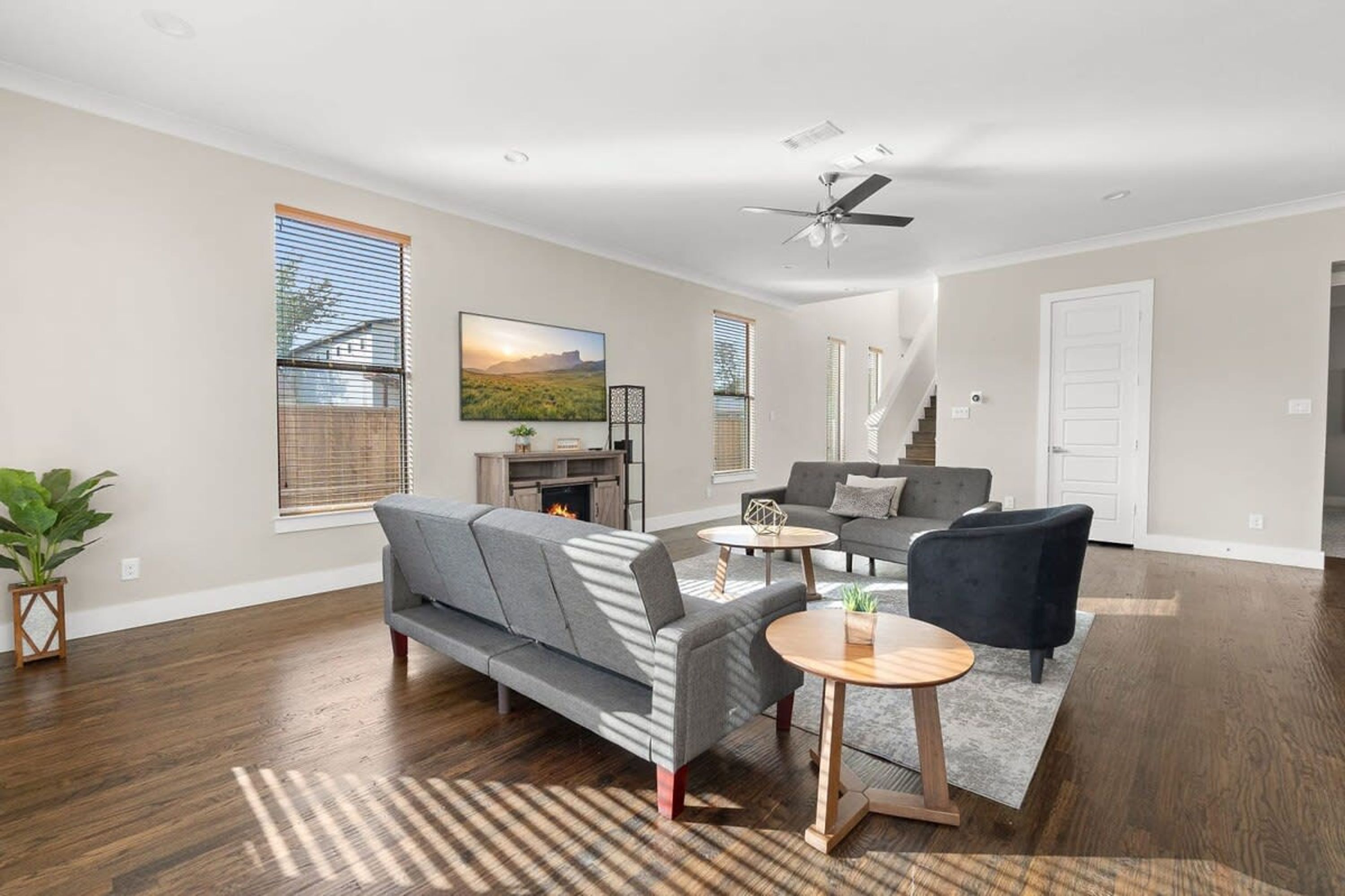 A spacious living room with a gray sofa, a coffee table, and a fireplace.