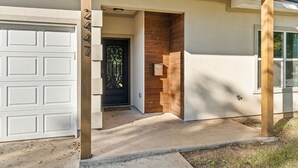A modern house with a garage, a wooden door, and a concrete driveway. - Large 3BD 2BR Lower Bishop Arts Near Downtown Dallas (Dallas)