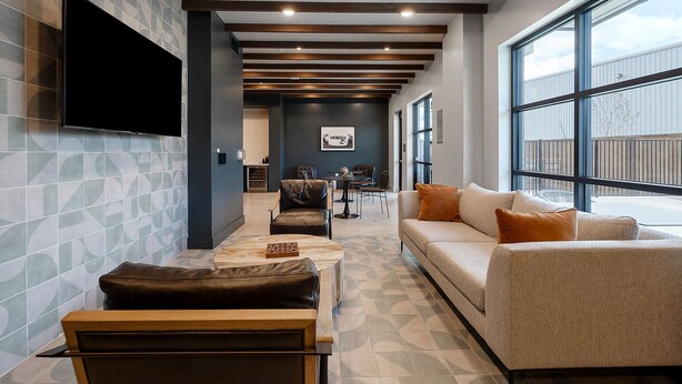 A modern living room with a sofa, a coffee table, and a TV mounted on the wall.
