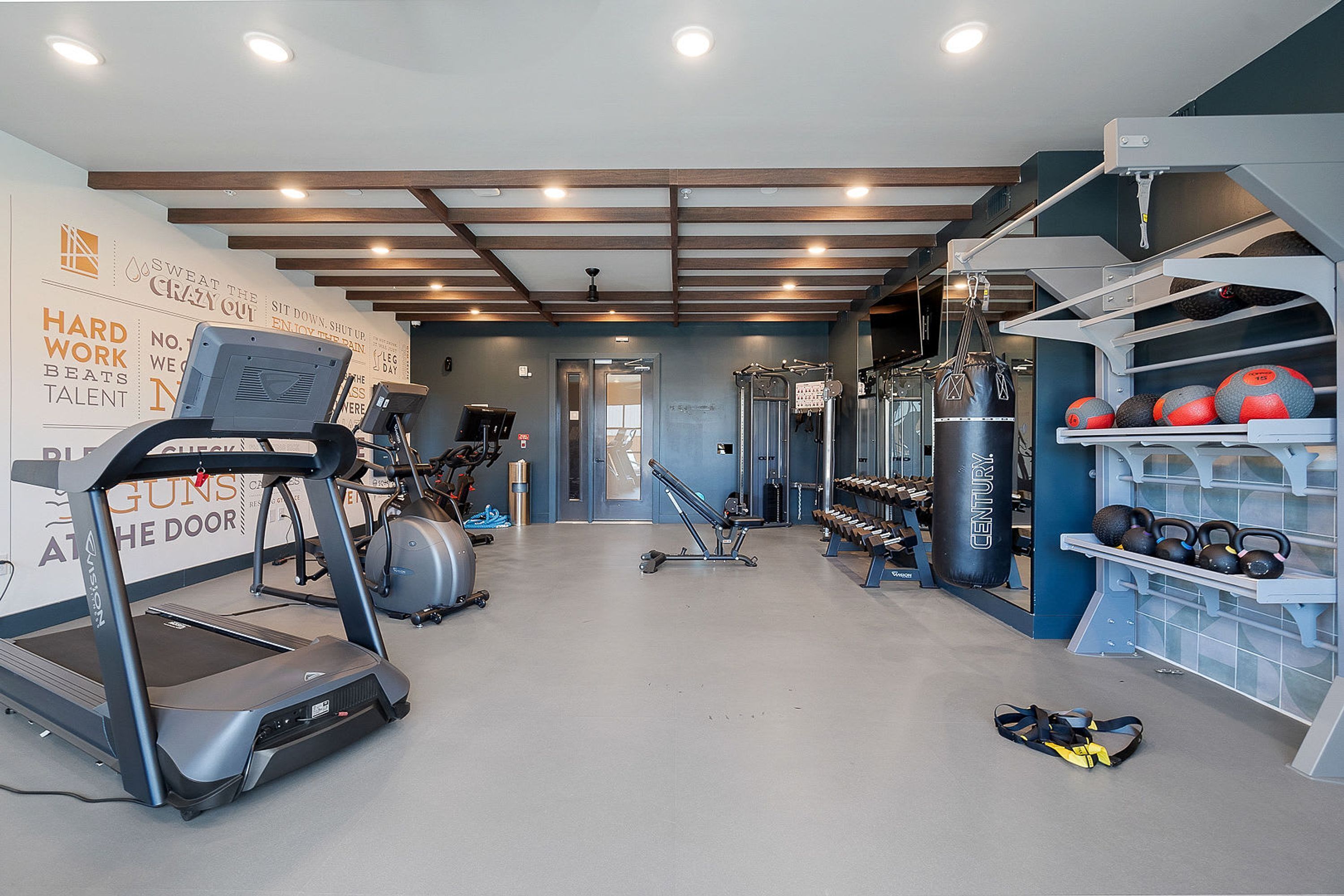 Ett gym med löpband, vikter och annan träningsutrustning.