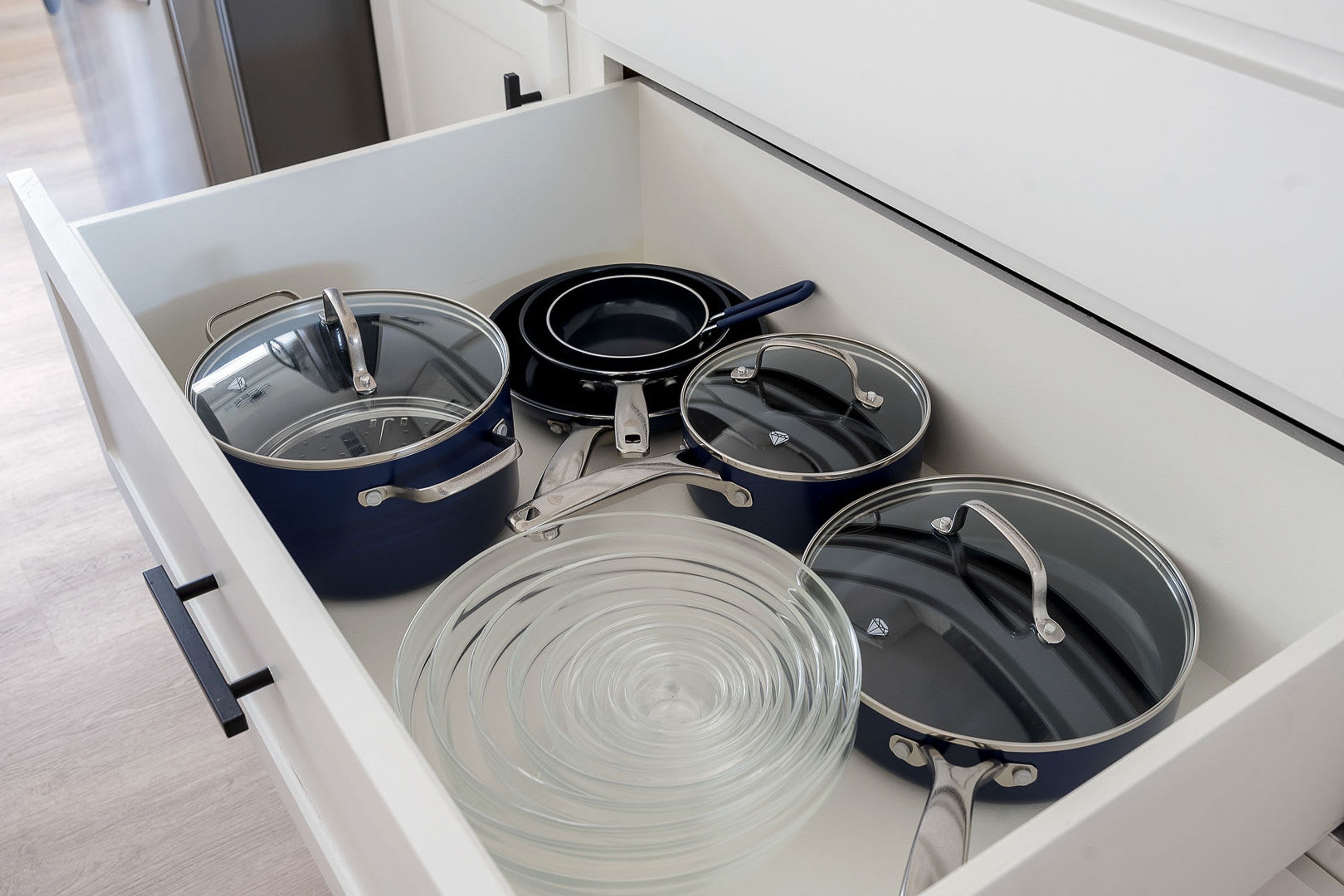 Un tiroir de cuisine contenant diverses casseroles et poêles.