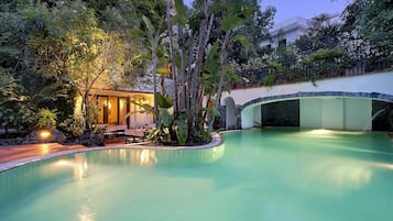 Una piscina al aire libre, sillones reclinables de piscina