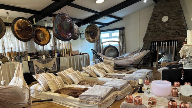 Un salon chaleureux avec un hamac, une cheminée et divers objets de décoration.