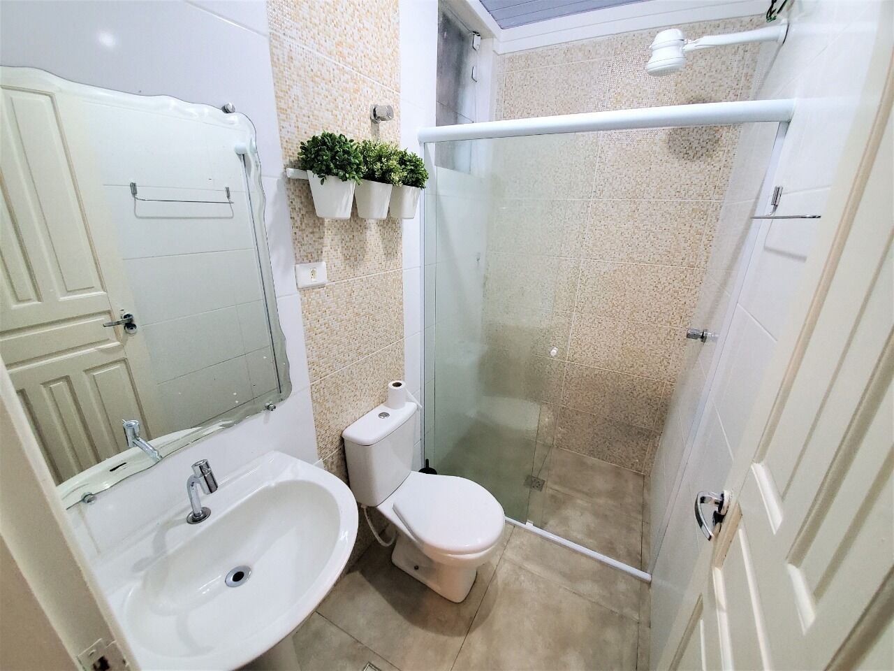 Een badkamer met wastafel, toilet en douchecabine.