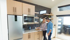A modern kitchen with stainless steel appliances, wooden cabinets, and a herringbone floor pattern. - Luxury Treehouse Retreat with Private Hot Tub (Branson)