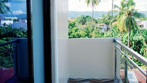 A balcony with a view of palm trees and houses. - Rb's Three Storey House (Zamboanga)