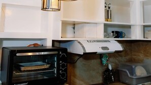 A kitchen with a built-in oven, a stove, and pendant lights. - Rb's Three Storey House (Zamboanga)