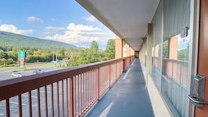 Een balkon met uitzicht op een parkeerplaats en een hotelscherm.
