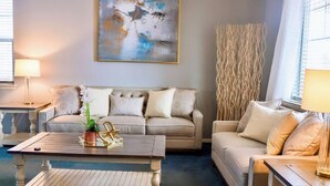 A living room with two sofas, a coffee table, and a painting on the wall. - Immaculate Home in Aurora (Aurora)