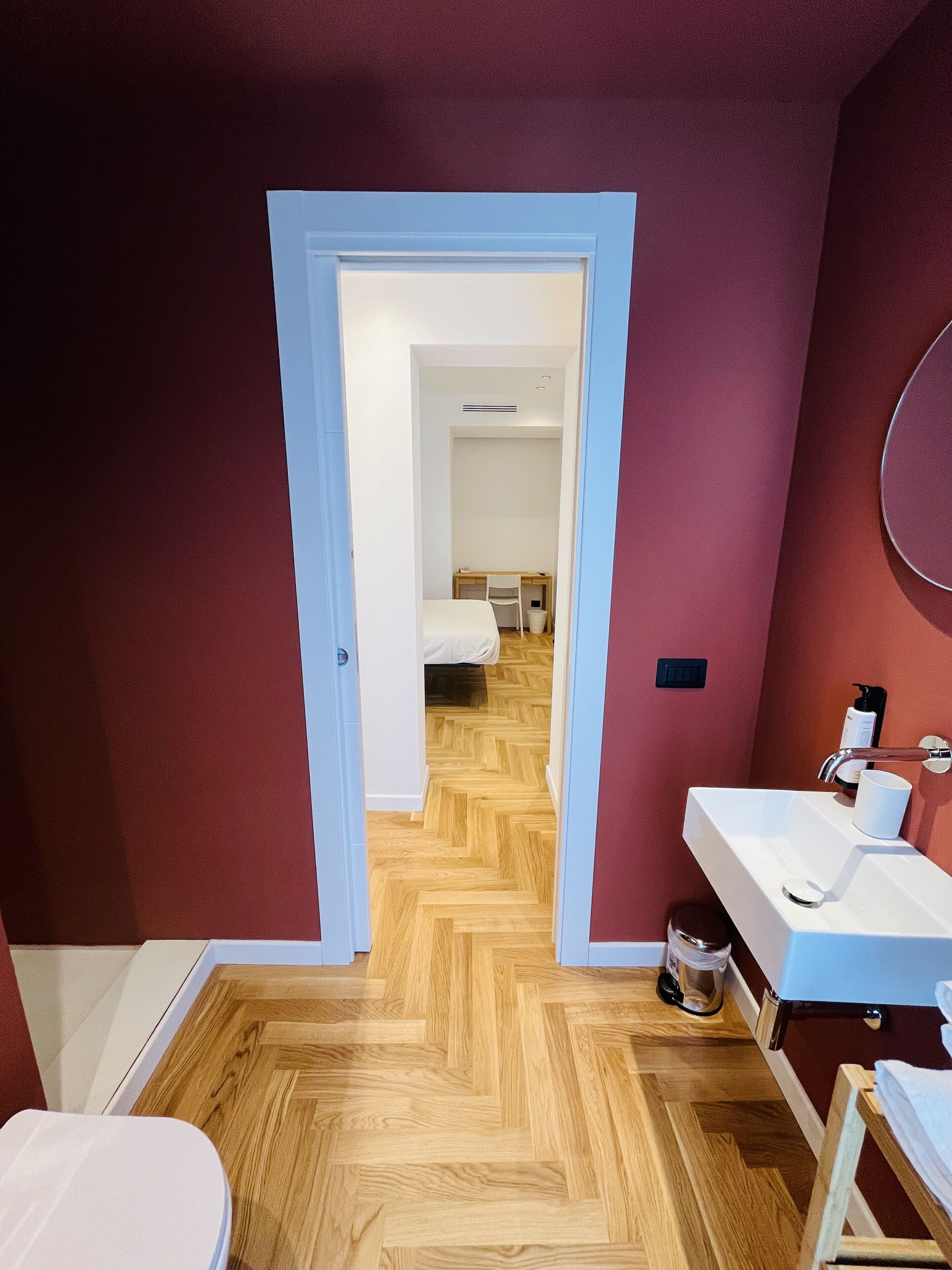 A modern bathroom with a white sink, a mirror, and a shower area.