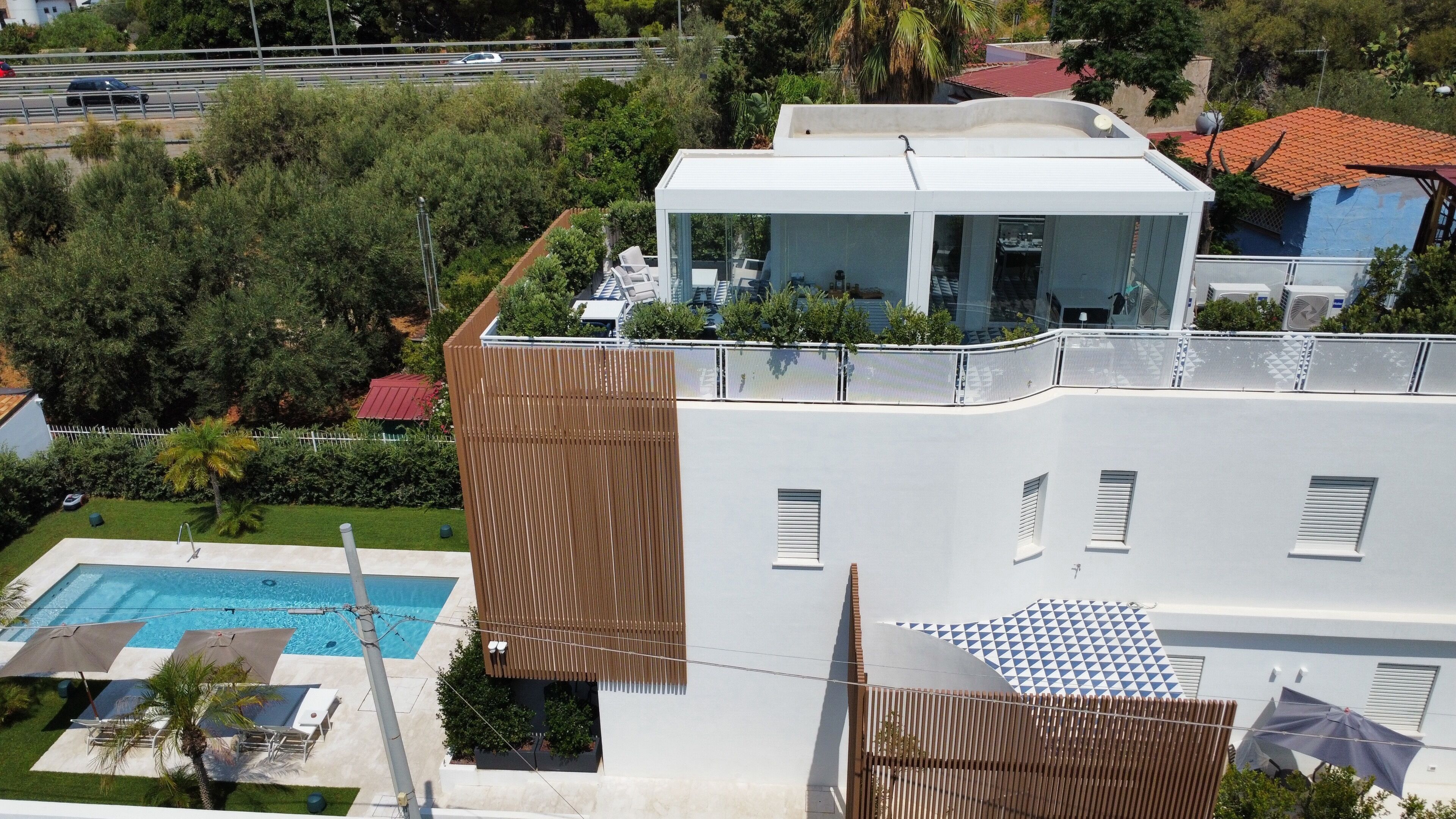 Un bâtiment moderne doté d’une terrasse sur le toit, d’une piscine et offrant une vue sur les environs.