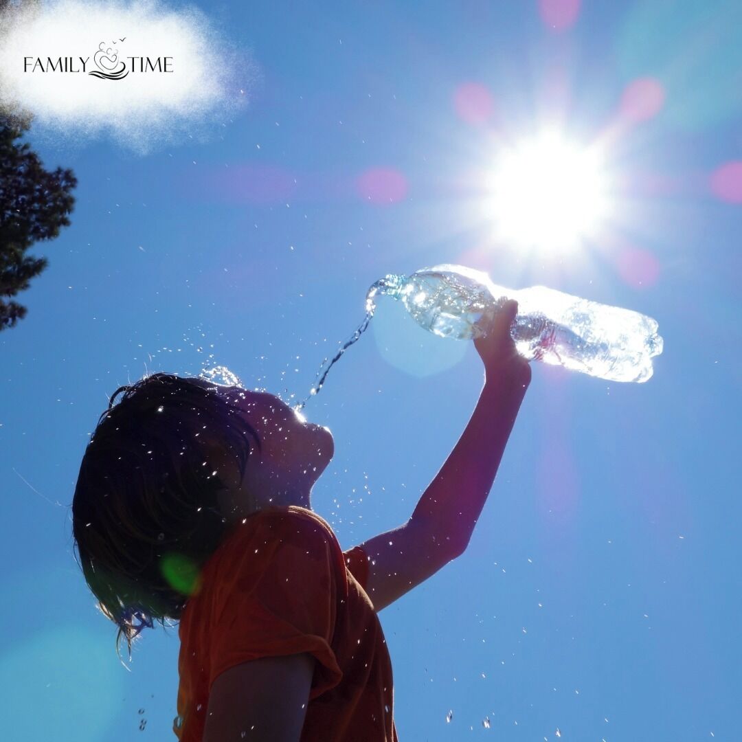 A person drinking from a clear plastic bottle against a bright sky.