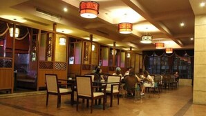 A restaurant with wooden partitions, tables, and chairs.