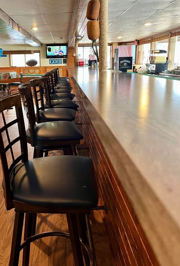 A bar area with wooden chairs and a long counter.
