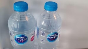 Kaksi Nestlé Pure Life -mineraalivesipulloa, joissa on siniset korkit.