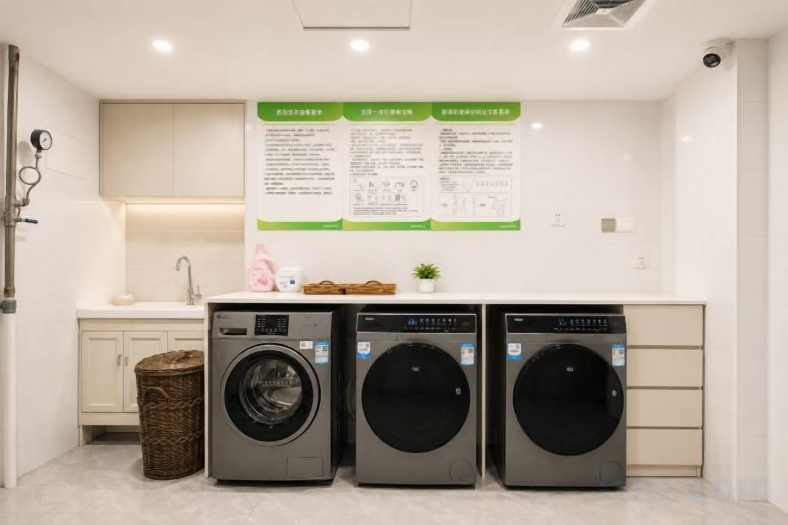 A laundry area with three washing machines, a sink, and a wall-mounted instruction manual.
