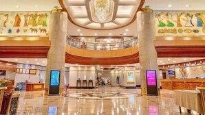 A spacious lobby with a central chandelier, a reception desk, and a circular decorative floor pattern. - Overseas Chinese Hotel (Nan'an)