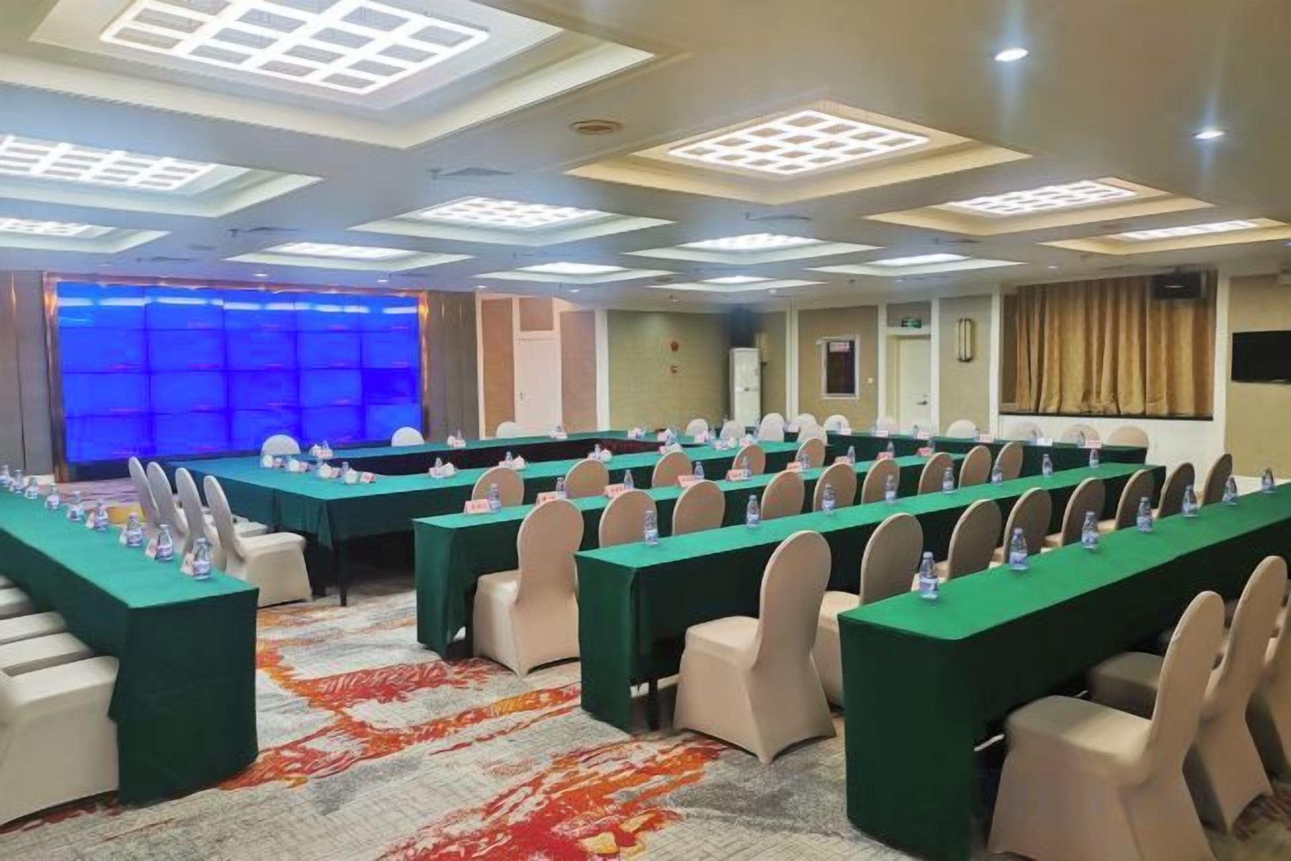 Un salón de conferencias con varias mesas y sillas, equipado con tarjetas de identificación y botellas de agua.