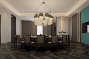 A dining area with a round table, chairs, and a chandelier. - Overseas Chinese Hotel (Nan'an)