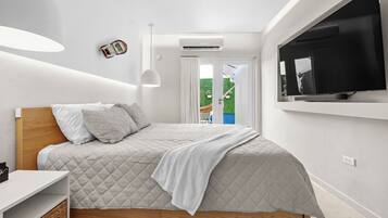 A modern bedroom with a bed, a TV, a ceiling light, and an air conditioning unit.
