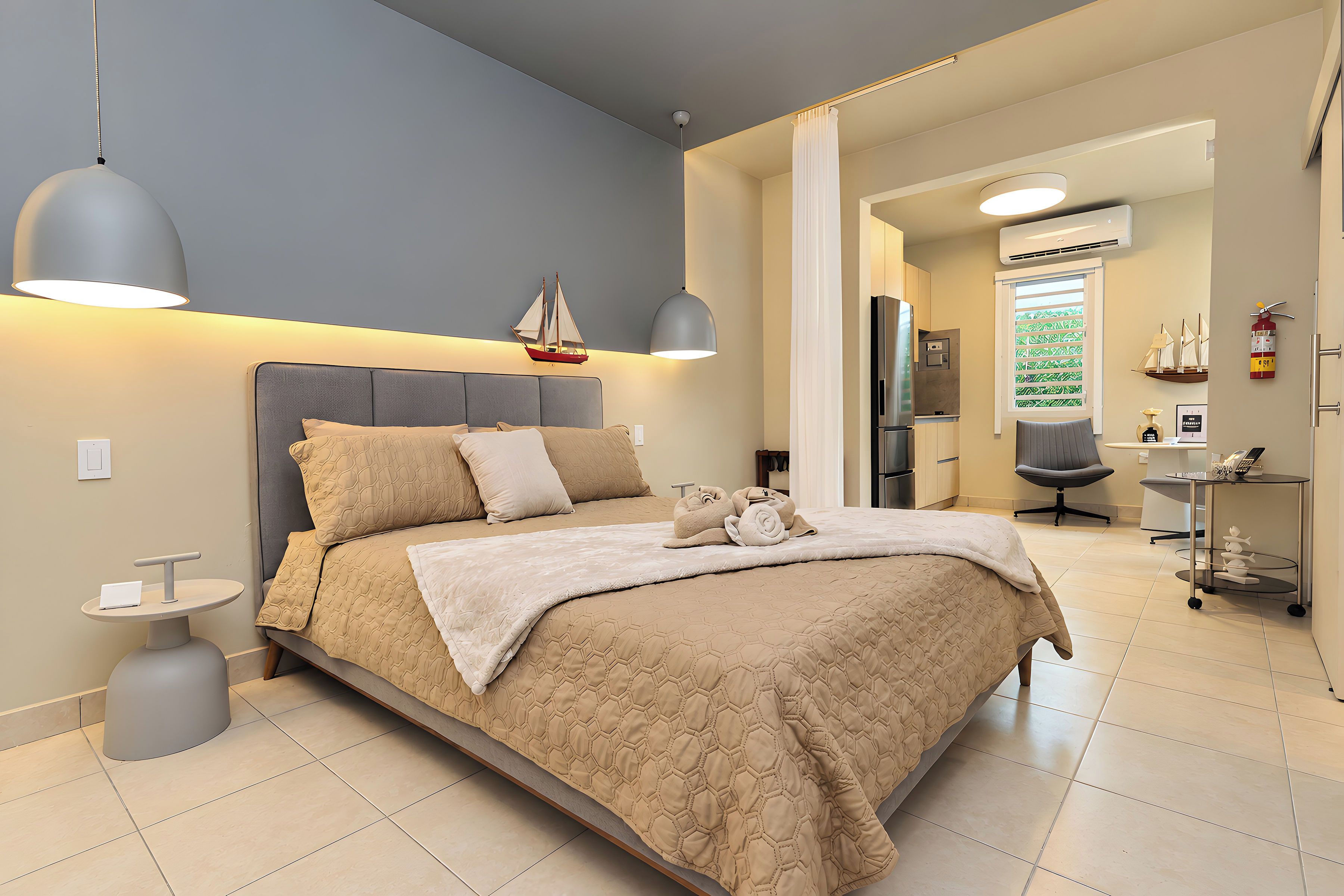 Una camera da letto moderna con un letto grande, lampade ai comodini e vista sul soggiorno comunicante.
