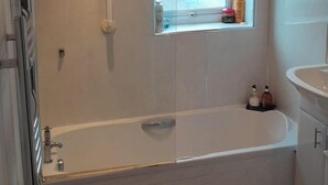 Un bagno moderno con vasca, finestra e water.
