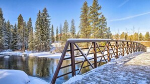 A metal bridge over a frozen river with snow-covered trees and a clear sky. - Walk to town and slopes, family friendly 2-bedroom condo w/ WiFi in Breckenridge (Breckenridge)