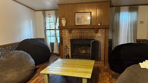 A living room with a fireplace, wooden flooring, and two bean bags.