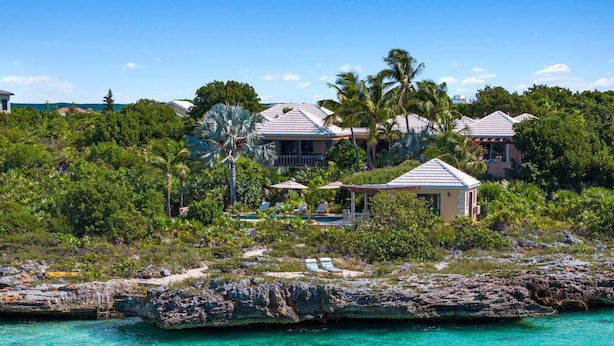 A coastal property with multiple buildings, a swimming pool, and lush greenery. - Villa Caona, Quintessential Caribbean Oceanfront Home (Providenciales)