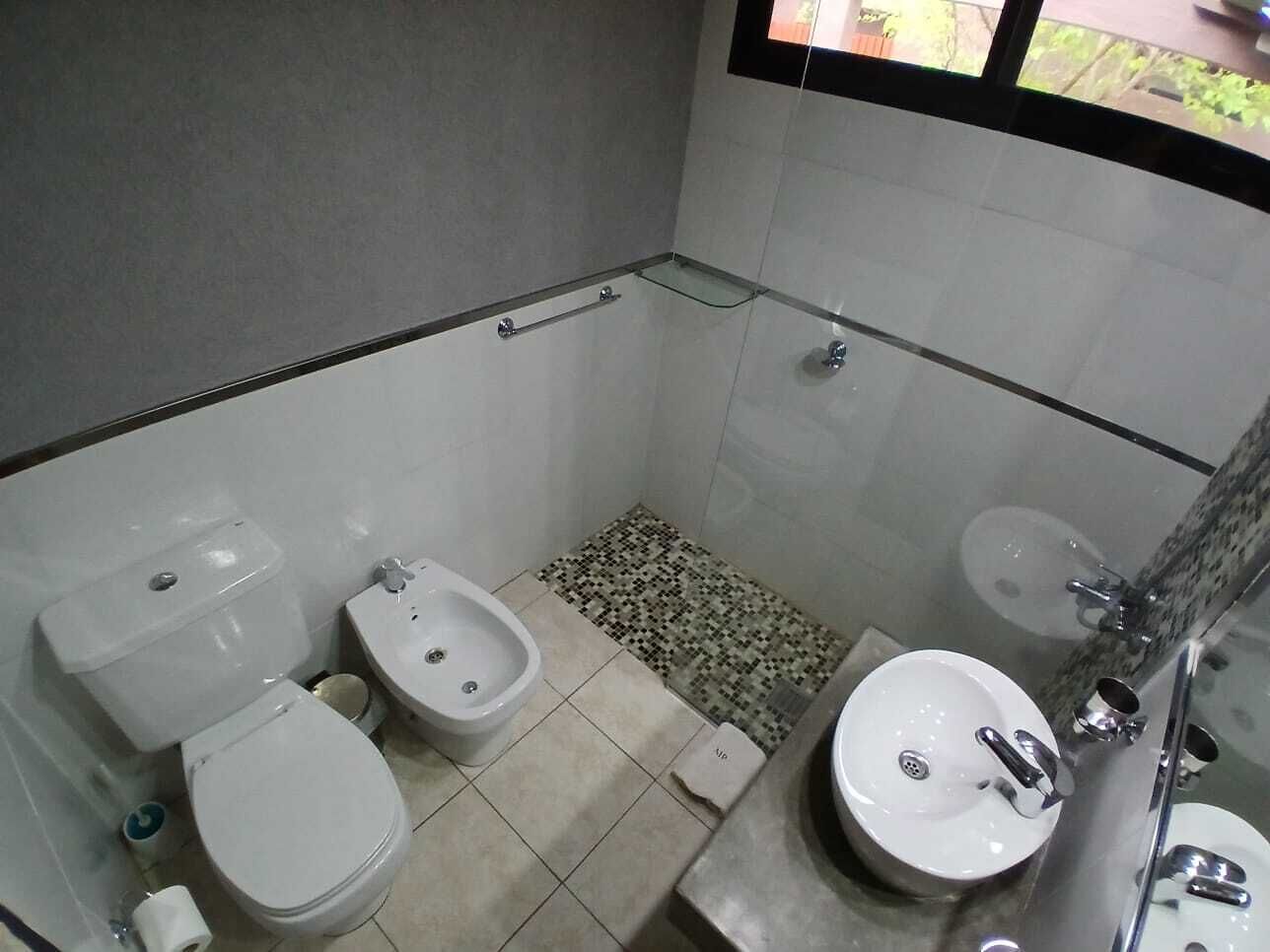 A small, compact bathroom with a toilet, bidet, and sink.