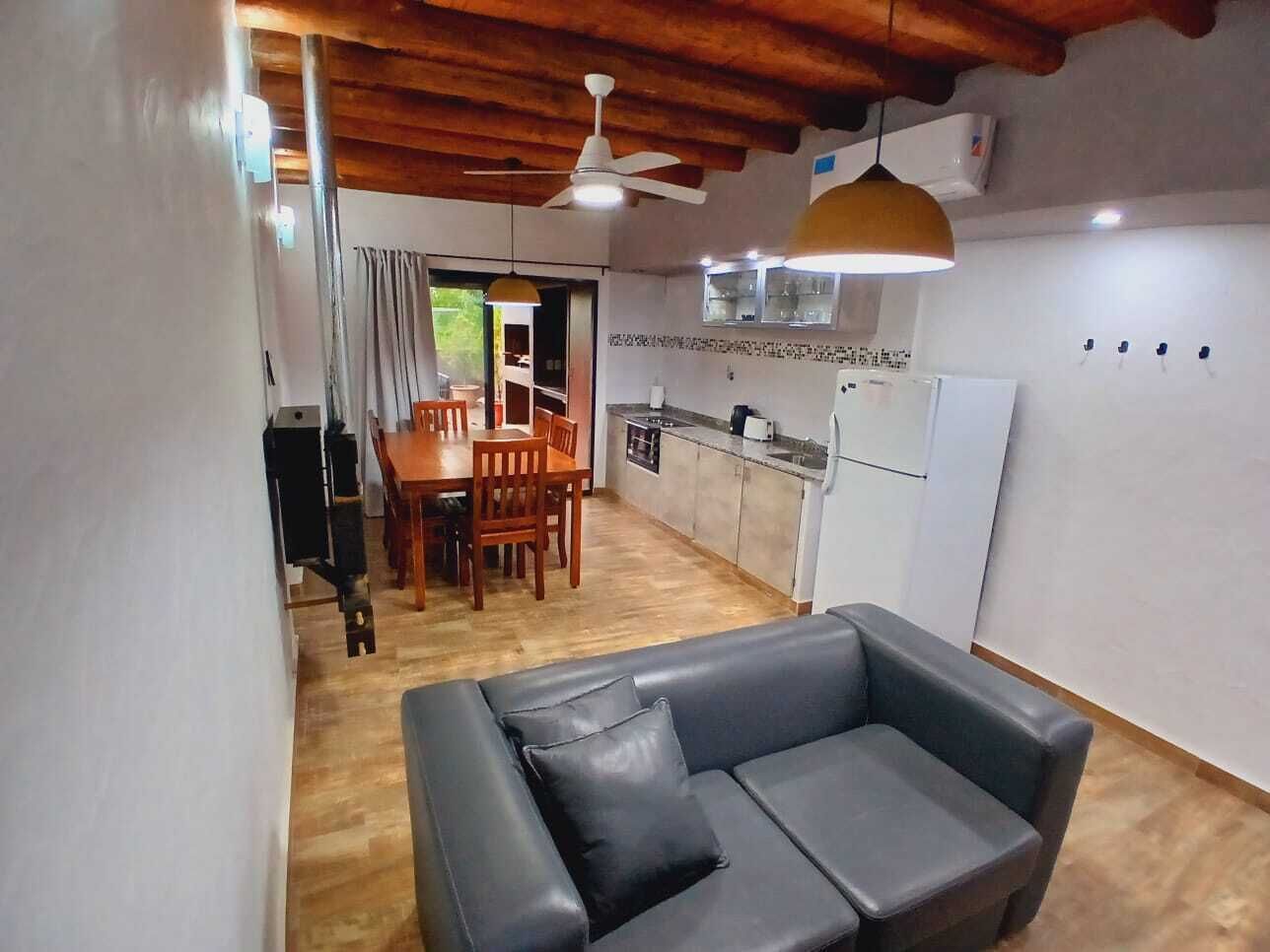 A compact living space with a dining area, kitchenette, and a sofa.
