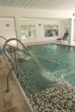 An indoor swimming pool with clear water, metal handrails, and a tiled floor. - La Divina Pereza Eco (San Rafael)